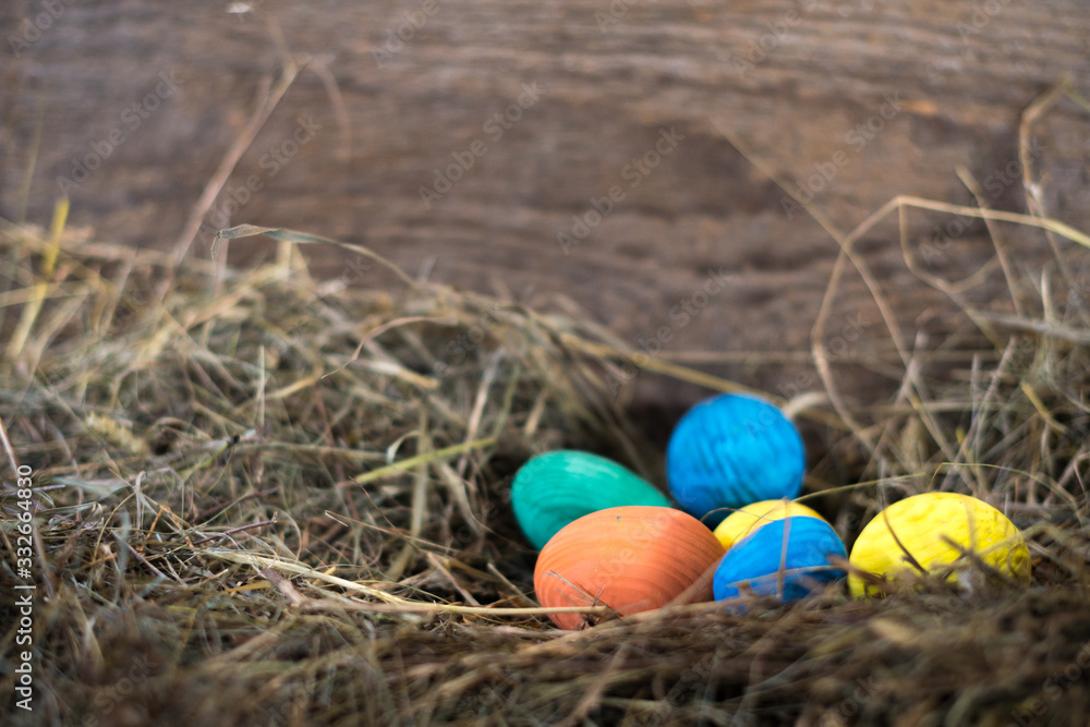 Obraz premium Easter eggs in a basket on a hay with a blurred background