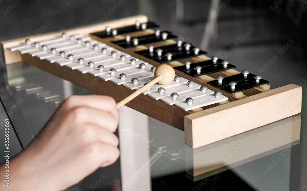 Xylophone closeup with a hammer in a child's hand Xylophone closeup with a hammer in a child's hand