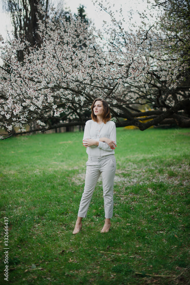 Beautiful young girl is resting and enjoying spring in the spring park Beautiful young girl is resting and enjoying spring in the spring park
