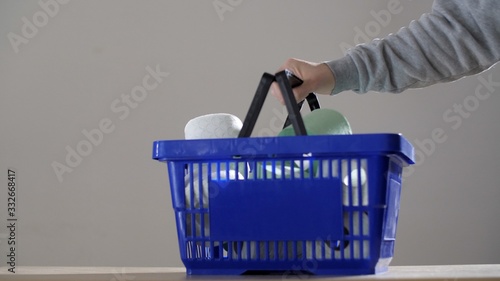 Male hands throw many of toilet paper in the shopping basket. Coronavirus or COVID-19. Epidemic situation. 