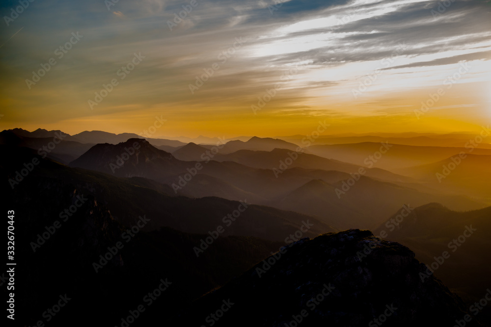Dark silhouettes of the Carpathian rocky mountains and yellow sunset sky Dark silhouettes of the Carpathian rocky mountains and yellow sunset sky