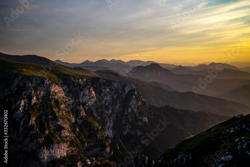 Dark silhouettes of the Carpathian rocky mountains and yellow sunset sky