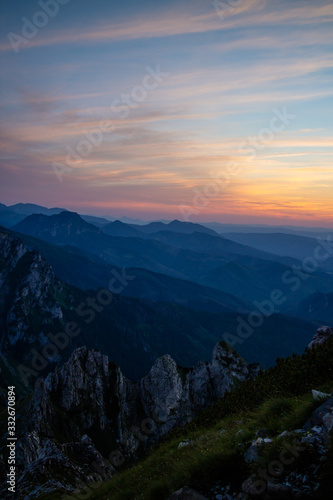 Fototapeta Naklejka Na Ścianę i Meble -  Blue silhouettes of Carpathian rocky mountains and sunset orange-blue sky with clouds