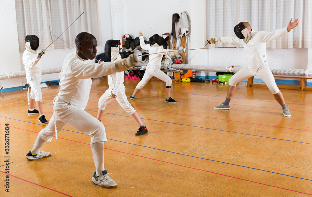 African American wearing fencing uniform practicing with foil