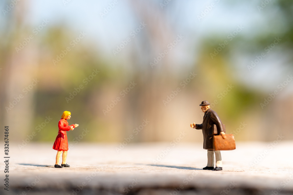 Obraz premium Miniature people greeting to keep social distancing to protect from COVID-19 coronavirus