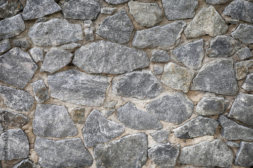 Cracked real stone wall surface with cement