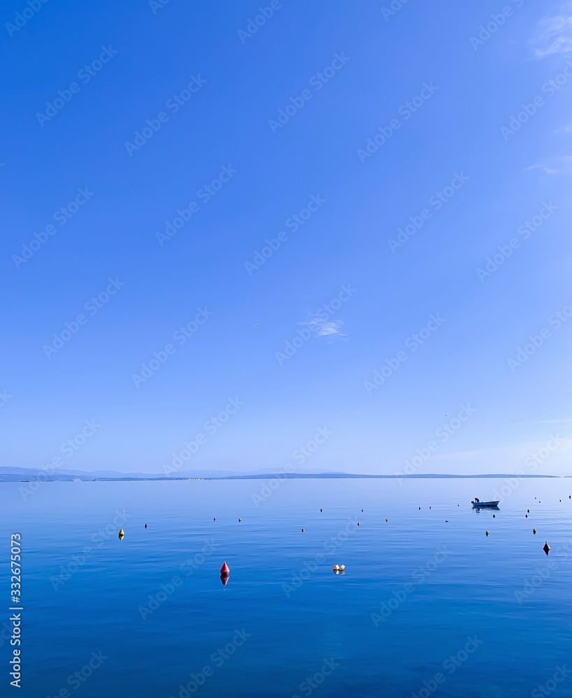 Blue sea and sky background, silhouette of lonely boat