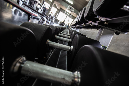 Row of big dumbbell in fitness gym