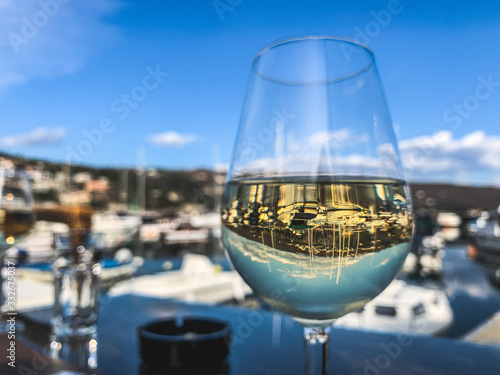 A glass of white wine in the sea harbor restaurant 
