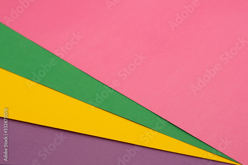 Multi colored paper background of pink, green, yellow and purple.