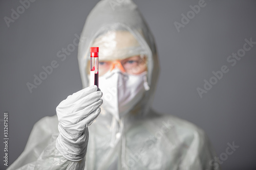 ist working in laboratory. Medical worker in protection clothes, mask, glasses, gloves with blood sample. Coronavirus outbreaking. Epidemic virus respiratory syndrome