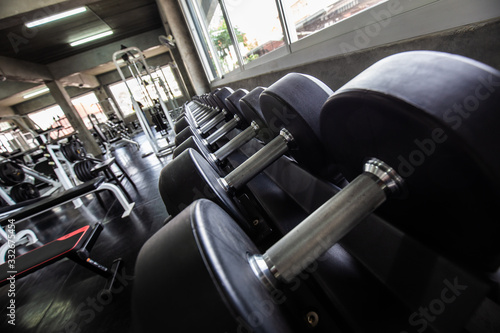 Row of big dumbbell in fitness gym