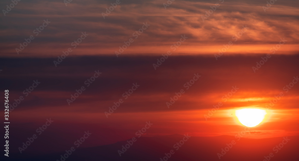 Mountains silhouettes, beautiful colorful dark sunset sky with orange clouds. Nature sky background.
