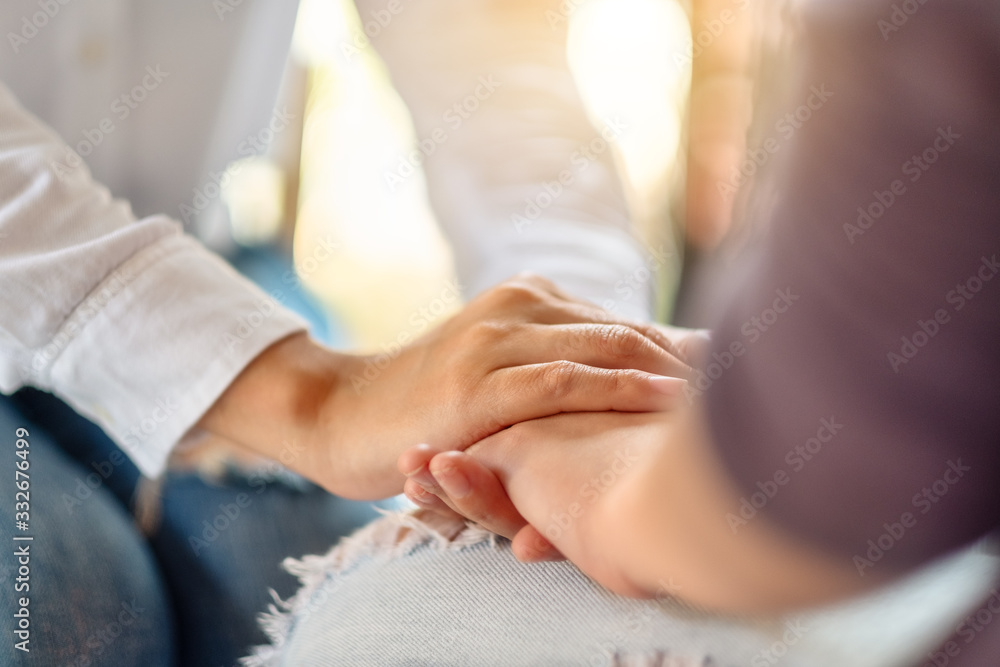 Obraz premium Women holding each other hands for comfort and sympathy