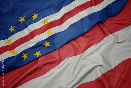 waving colorful flag of austria and national flag of cape verde.
