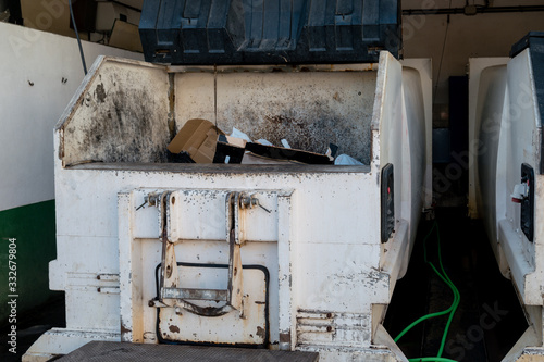 A large open communal waste bin or portable rubbish compactor