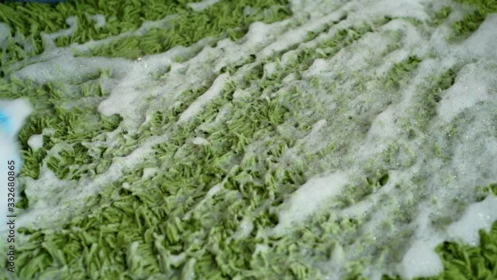 Green carpet in the foam. Services of home cleaning Green carpet in the foam. Services of home cleaning