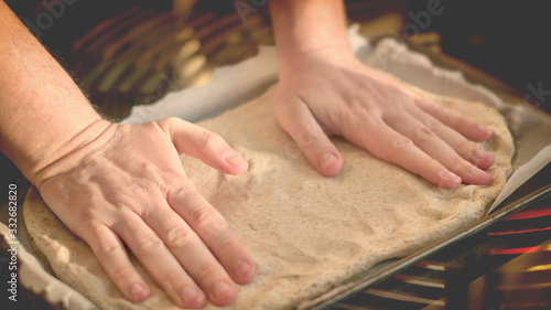 hands forming dough stretch on bakin sheet with olive oil - homemade rustic pizza italian cookery horizontal background © Luca Lorenzelli