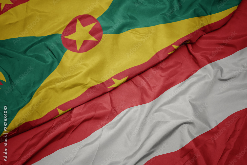 waving colorful flag of austria and national flag of grenada.