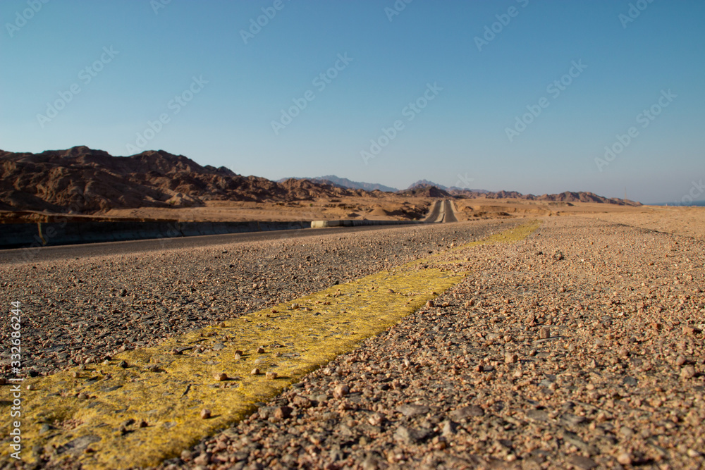  long road in the desert with the blue and clear sky