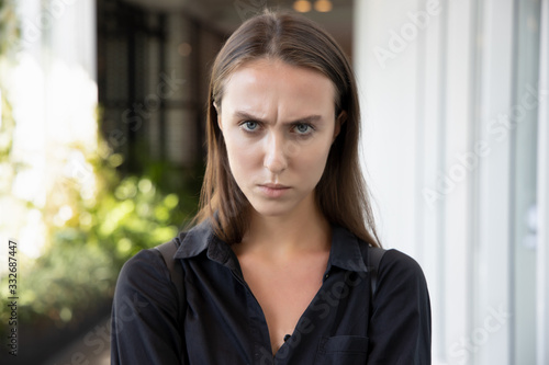 face portrait of unhappy angry upset woman; portrait of negative angry displeased frustrated caucasian white woman; young adult Russian caucasian woman model