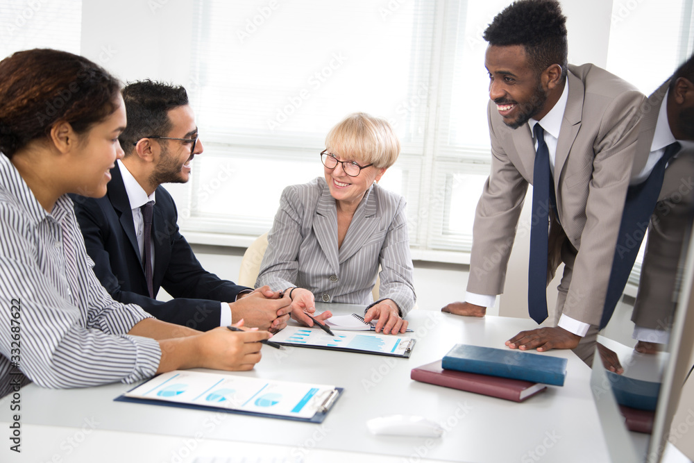 International group of business people working and communicating sitting near office desk. International group of business people working and communicating sitting near office desk.