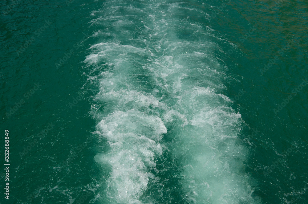 Traces on the water from the ship. Sea surface. Natural background, summer.