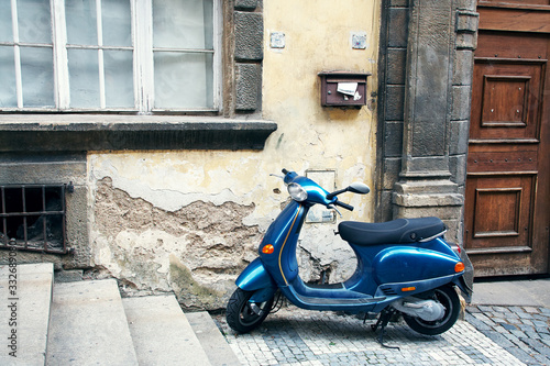 Blue vintage scooter parked in a city.