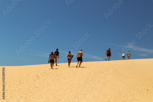 Group of friends walking up a sand dune