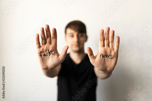 Fake news - text on men's hands. The concept of deception in media and politics. The social problem of the modern world