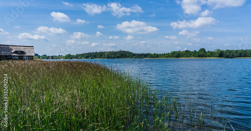 Ausblick auf den Krakower See mit Schilfgras und Bootshaeusern