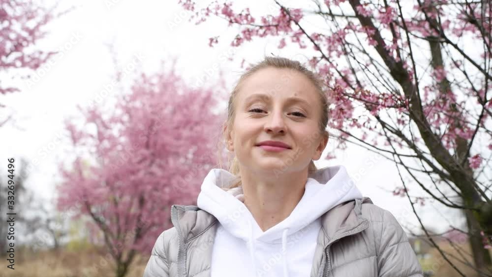 Woman takes off medical mask and enjoying blooming tree after allergy Woman takes off medical mask and enjoying blooming tree after allergy