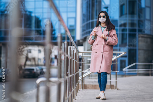 Female in medical mask outdoors in the empty city. Health protection and prevention of virus outbreak, coronavirus, COVID-19, epidemic, pandemic, infectious diseases, quarantine concept.