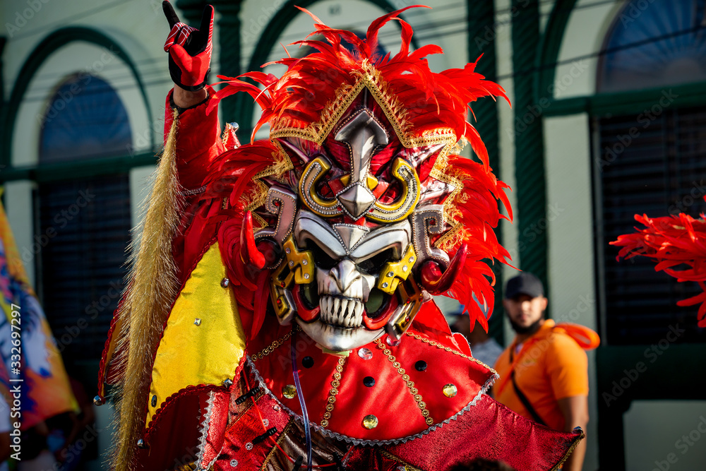 closeup man in vivid carnival costume poses for photo on dominican city street
