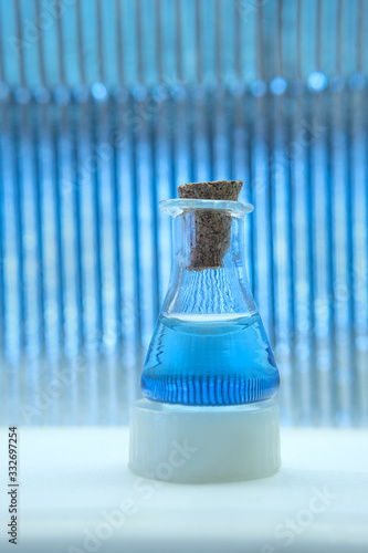 Test tube with color solution on blue laboratory background