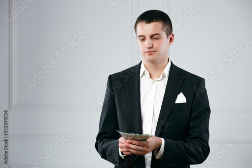 Portrait of a focused serious successful businessman holding money