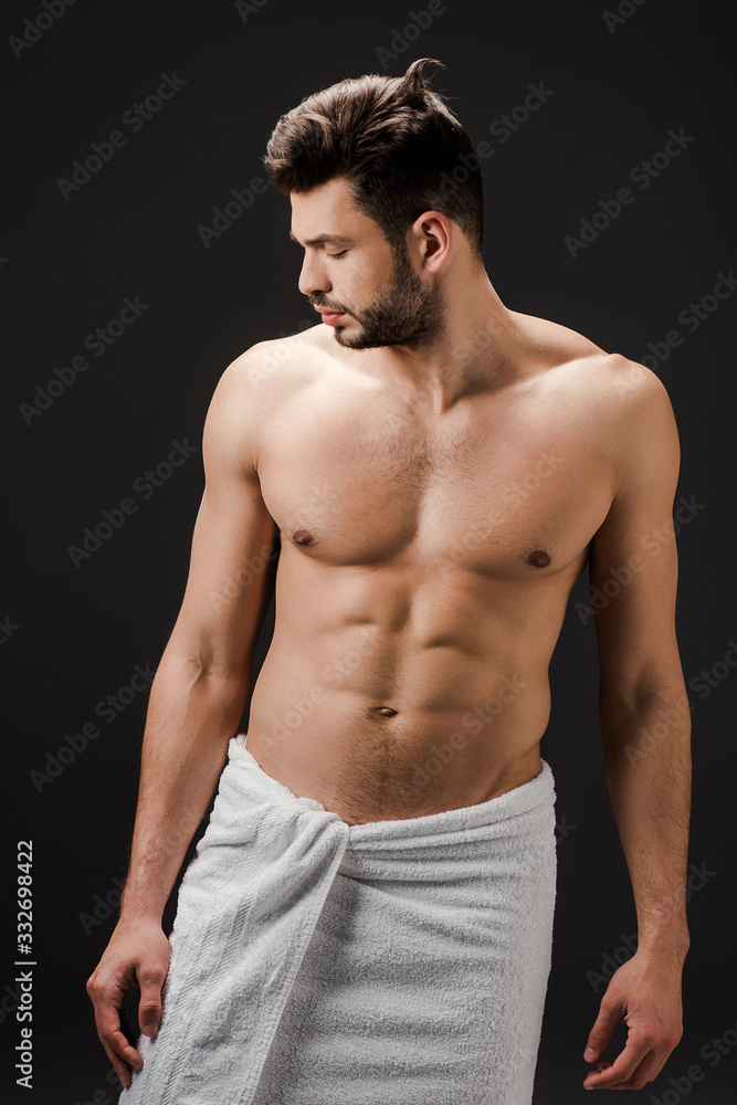 handsome brunette sexy man in towel isolated on black