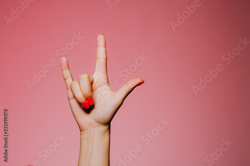 Woman's hands with bright manicure isolated on pink background hevy metal sign photo