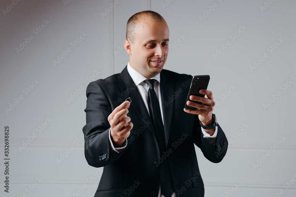 Businessman proposes with ring in hand while look on the phone Businessman proposes with ring in hand while look on the phone