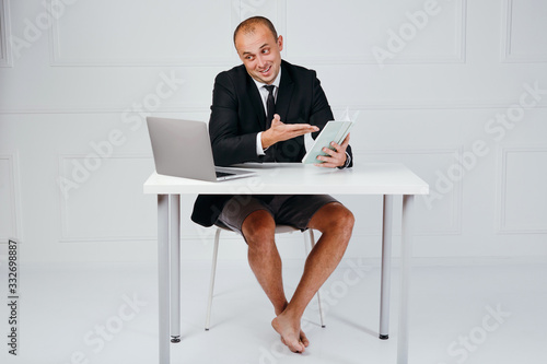 Happy businessman in suit using laptop in office photo