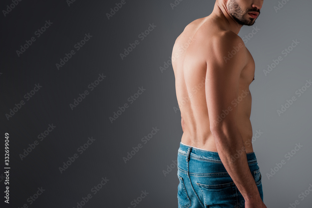 cropped view of shirtless man in jeans on grey