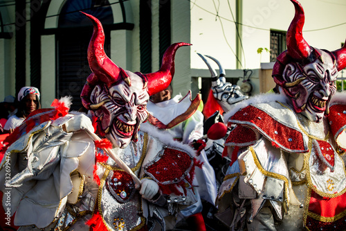closeup people in scary devil costume pass by city street at dominican carnival