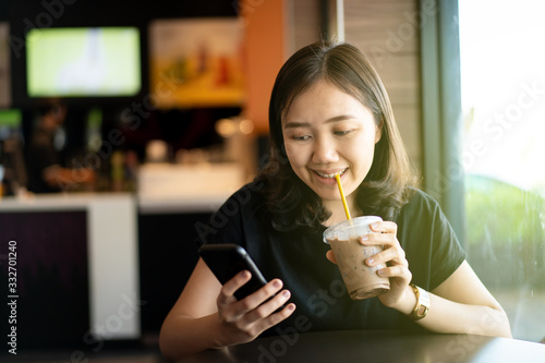 Beautiful happy Asian woman sitting at the coffee shop and restaurant  woman looking away with copyspace on blurred background. thoughtful and inspired creativity woman enjoy relaxing at coffee shop.