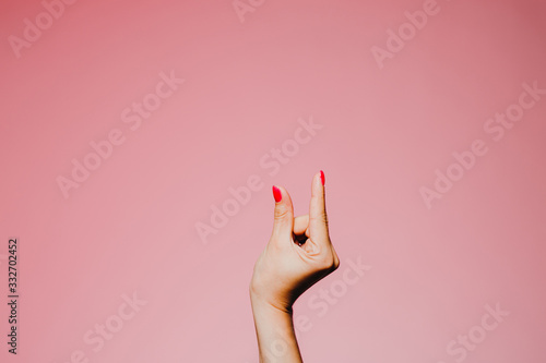 Foto Woman's hands with bright manicure isolated on pink background small size gestur