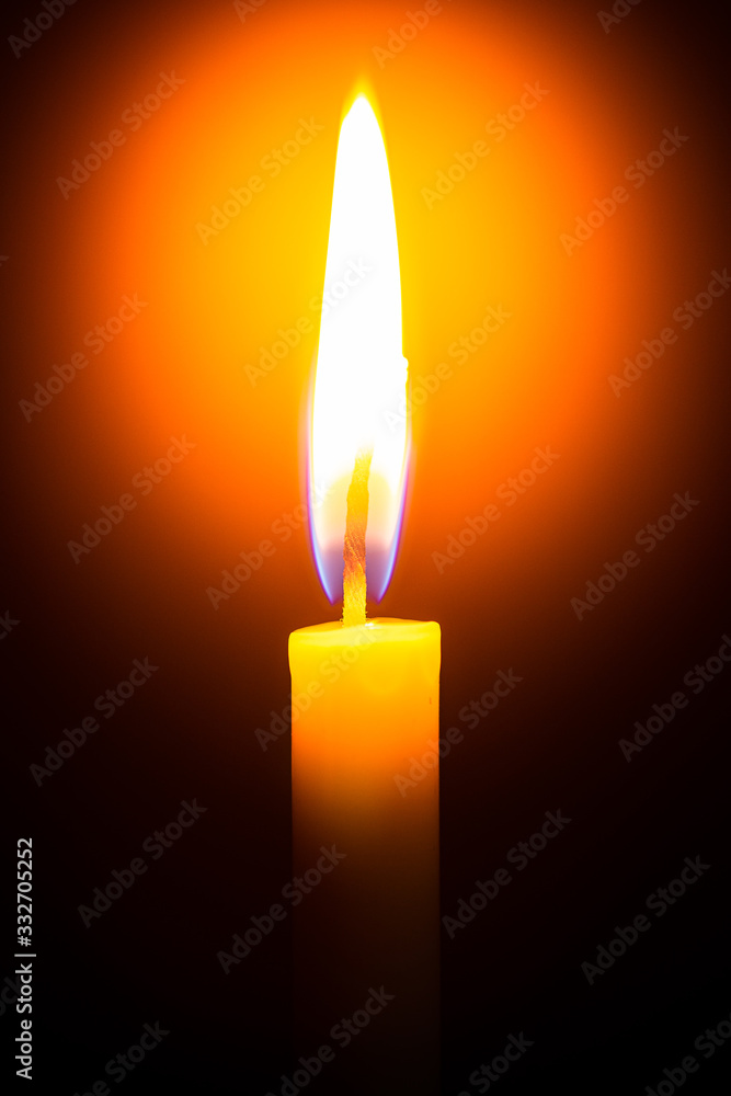 Red candle with yellow flame on black background Red candle with yellow flame on black background