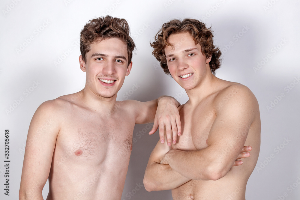Two naked guys hugs on a white background. Love, passion and relationships Two naked guys hugs on a white background. Love, passion and relationships