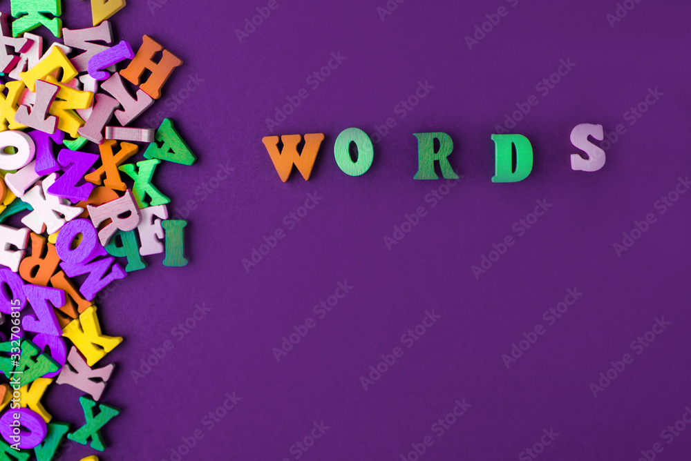 Word word made with block wooden letters next to a pile of other letters over the wooden board surface composition Word word made with block wooden letters next to a pile of other letters over the wooden board surface composition