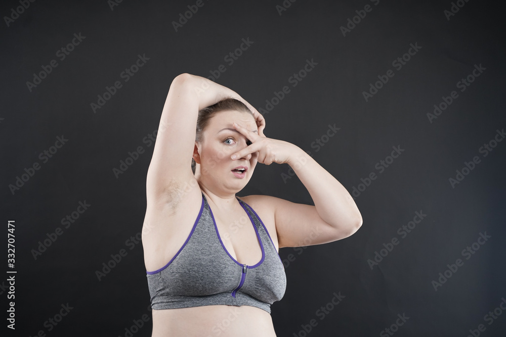unhappy woman shows her unshaved armpit. plus size middle age woman is not happy with hair in her armpits. Caucasian girl is emotional sad and upset. black background in the photo Studio. unhappy woman shows her unshaved armpit. plus size middle age woman is not happy with hair in her armpits. Caucasian girl is emotional sad and upset. black background in the photo Studio.