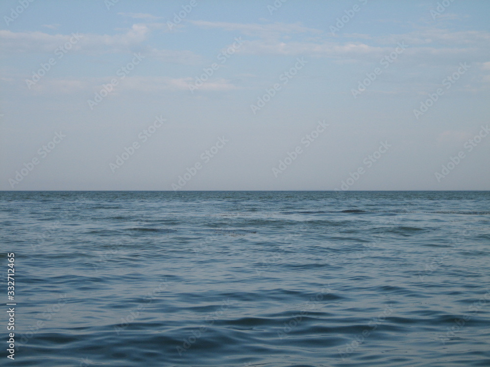 Obraz premium A flat horizon between the sky and the sea at sunset on a clear day.