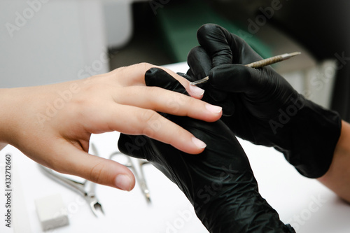 Manicurist removing cuticle for a beauty salon client